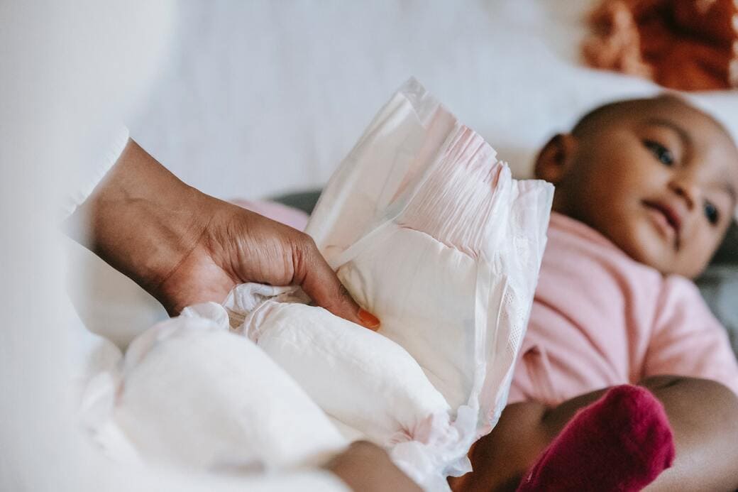 Maman qui change la couche de son bébé