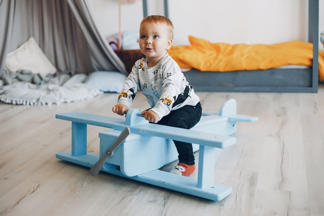 un bébé sur un avion en bois